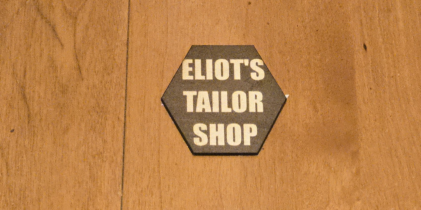 Hexagonal custom laser-cut wooden sign for 'Eliot's Tailor Shop' by PetiteTrace