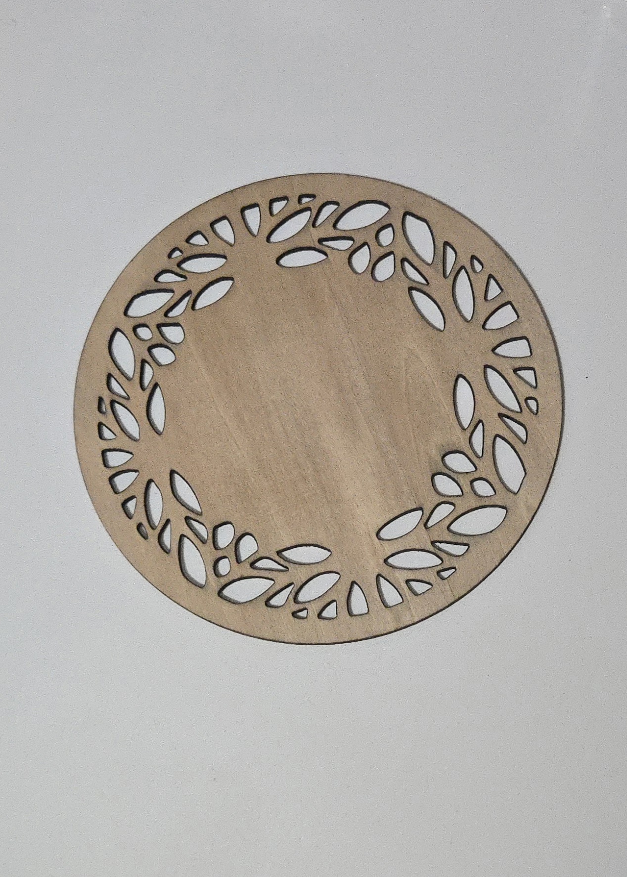 Oval laser-cut wooden frame with leaf border design by PetiteTrace