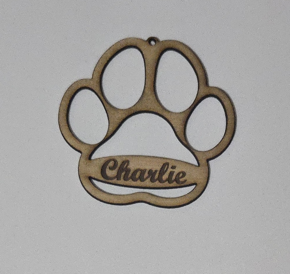 Custom laser-cut wooden paw print pet ornament with name 'Charlie' by PetiteTrace