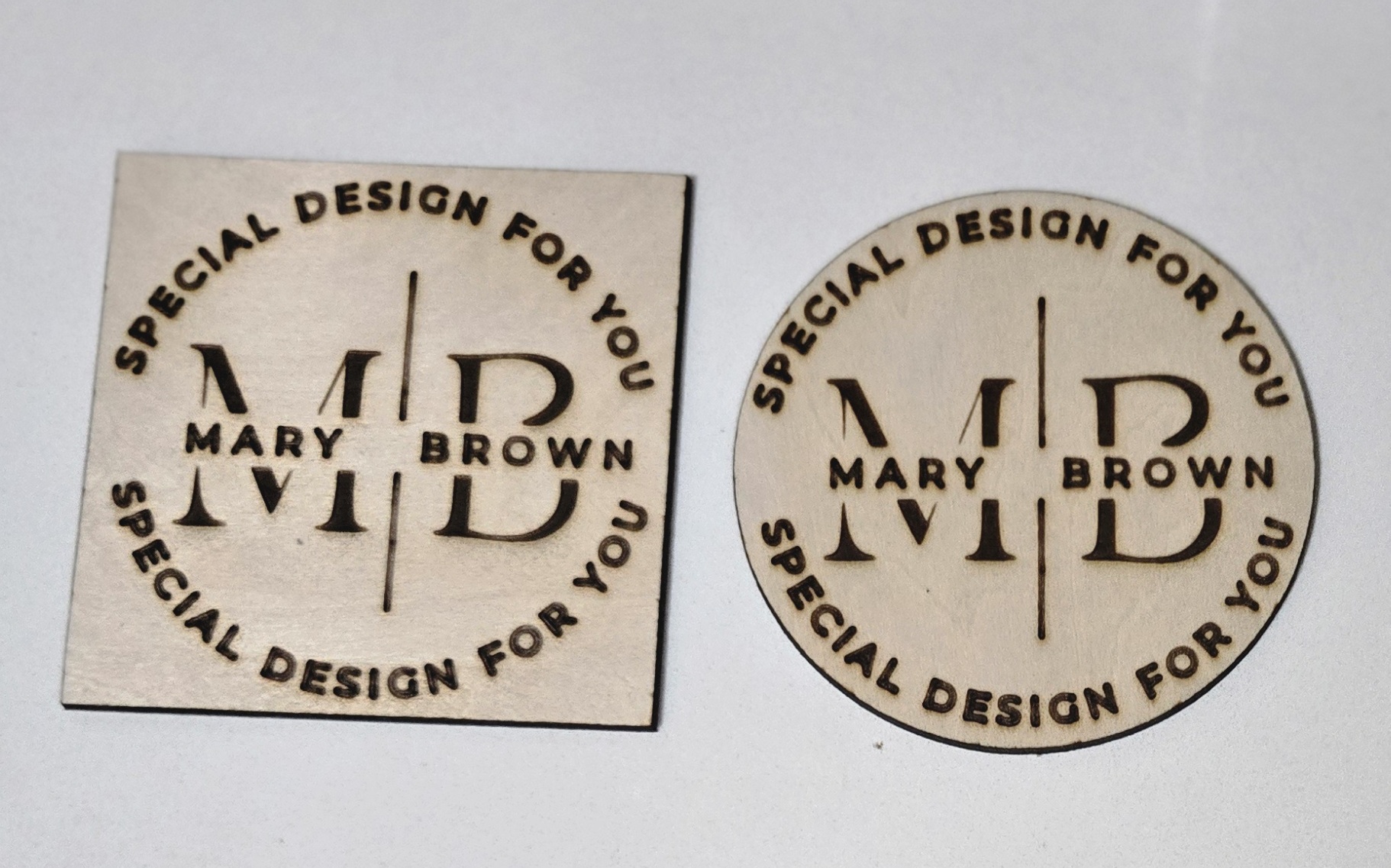 Custom laser-engraved wooden logo tags for 'Mary Brown Special Design' by PetiteTrace, square and circle