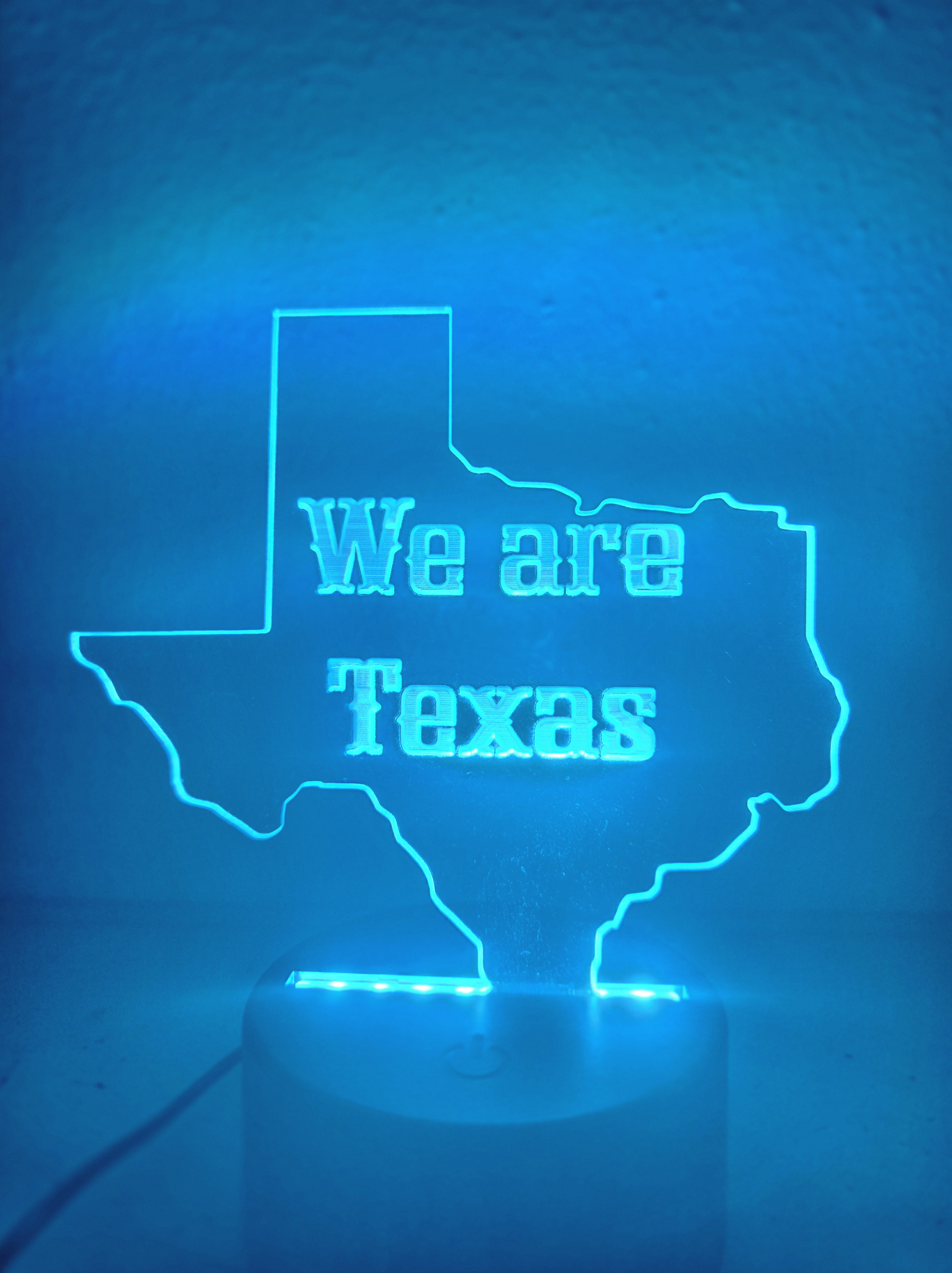 Custom 'We are Texas' LED acrylic night light sign, illuminated in blue, by PetiteTrace